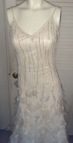 a mannequin wearing a white dress with lots of ruffles on it