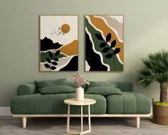 a living room with two paintings on the wall and a green couch in front of it