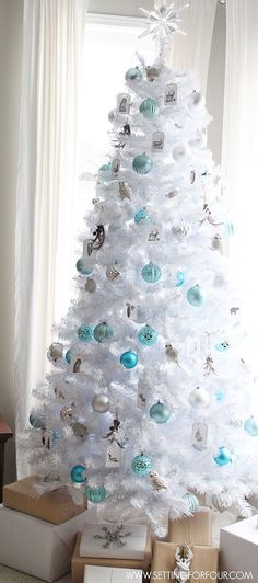 a white christmas tree with blue and silver ornaments