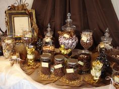 a table topped with lots of different types of candies and chocolates in glass jars