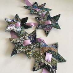 five star shaped ornaments with pink bows on them