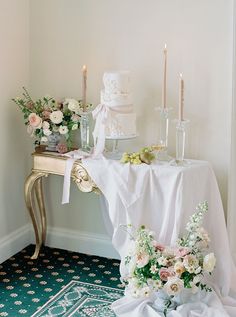 a table topped with a white cake and flowers