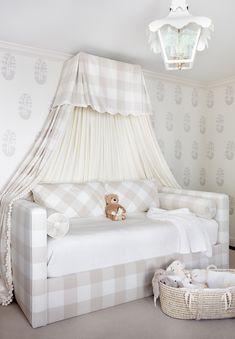 a white and gray bedroom with a teddy bear on the bed in front of it