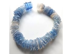 a blue and white bracelet on a white surface with an object in the middle of it