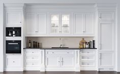 a kitchen with white cabinets and black counter tops