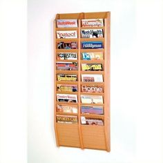 a wooden magazine rack holding magazines on it's sides and hanging from the wall