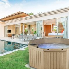 a hot tub sitting in the middle of a lush green yard next to a swimming pool