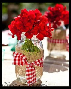 a cell phone with an image of red flowers in a mason jar on the screen