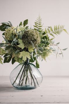 a vase filled with green and white flowers