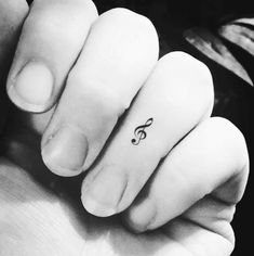 a person with a small treble on their left hand and a tiny tattoo on the middle finger