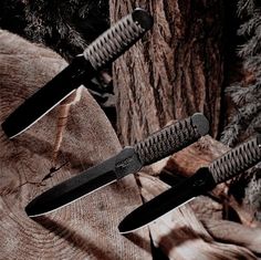 two knives sitting on top of a tree stump