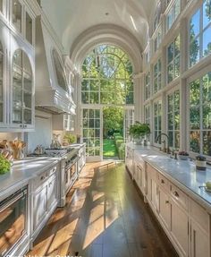 a large kitchen with lots of windows and white cabinets on both sides of the room