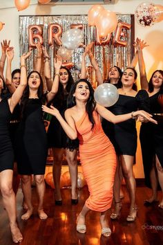 a group of women holding up balloons in the air