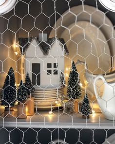 a shelf with christmas decorations and plates on it in front of a chicken wire fence