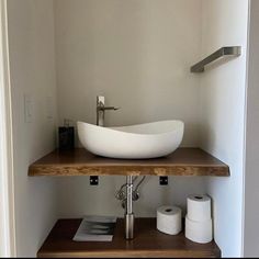 a bathroom sink sitting on top of a wooden shelf