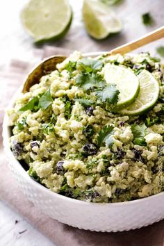 a white bowl filled with rice and garnished with cilantro