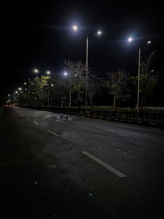 an empty road at night with street lights