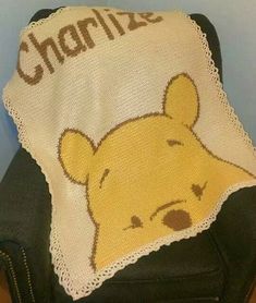 a crocheted winnie the pooh blanket on top of a chair