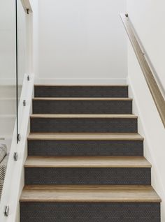 a set of stairs leading up to the second floor in a home with white walls and carpet