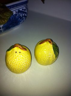 two oranges sitting next to each other on a white counter top in front of a blue and white bowl