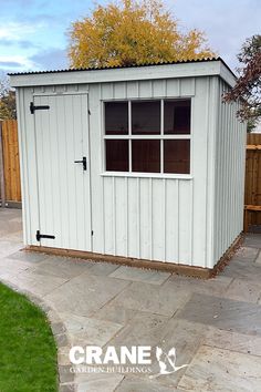 a small white shed sitting on top of a patio