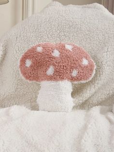 a mushroom stuffed animal sitting on top of a bed