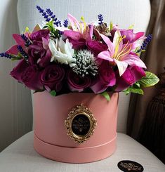 a pink hat box filled with purple and white flowers