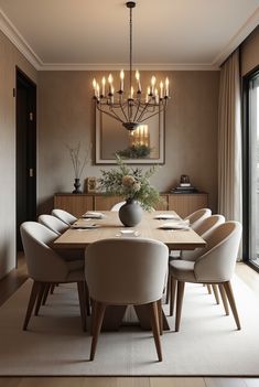 a dining room table with white chairs and a chandelier hanging from the ceiling