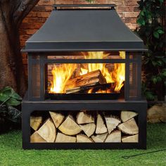 an outdoor fireplace with logs in the foreground