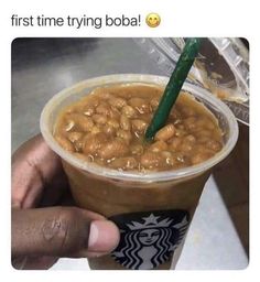 someone is holding up a cup of coffee with beans in it and the caption reads, first time trying boba