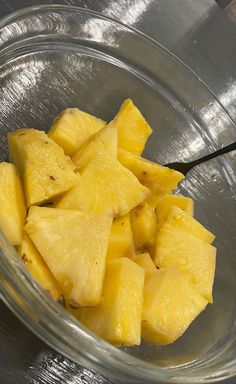 a glass bowl filled with cut up pineapples