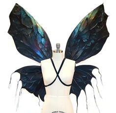 a mannequin wearing a black and blue costume with wings on it's back