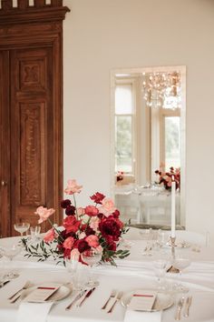 the table is set with flowers and place settings