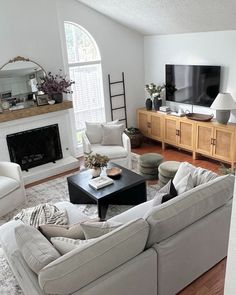 a living room filled with furniture and a flat screen tv on top of a fireplace