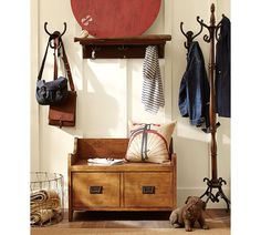 a wooden bench sitting next to a coat rack