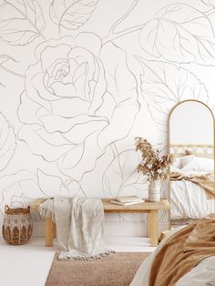 a bed room with a neatly made bed and a flower wall mural on the wall