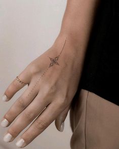 a woman's hand with a small tattoo on the left side of her arm