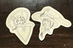 two stickers depicting the faces of women in hats and lassos on a wooden table