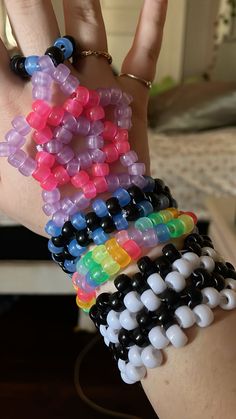 a person's hand with several bracelets on it