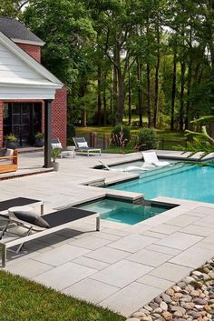 a backyard with a pool, patio and lounge chairs in the foreground is an outdoor living area