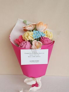 a bouquet of flowers is wrapped in pink paper