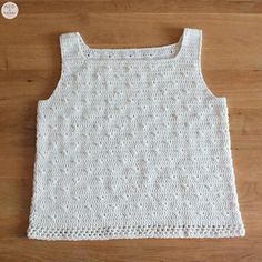 a white crocheted tank top on a wooden floor