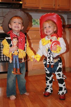 two children dressed up as toy story book characters, one in cowboy costume and the other in cowgirl costumes