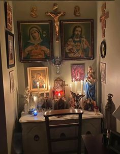 a small room with paintings and candles on the wall, including a crucifix