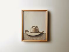 a painting of a cowboy hat hangs on the wall