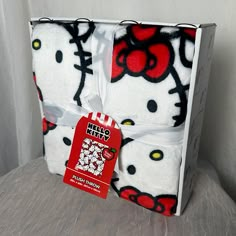 the hello kitty blanket is wrapped in white and has red, black, and yellow designs