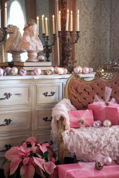 a bedroom with pink furniture and candles on the dresser