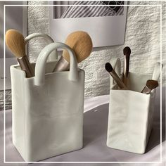 two white bags with makeup brushes in them