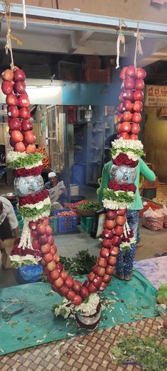 an arrangement of fruits and vegetables hanging from strings