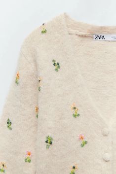 a white sweater with flowers on it